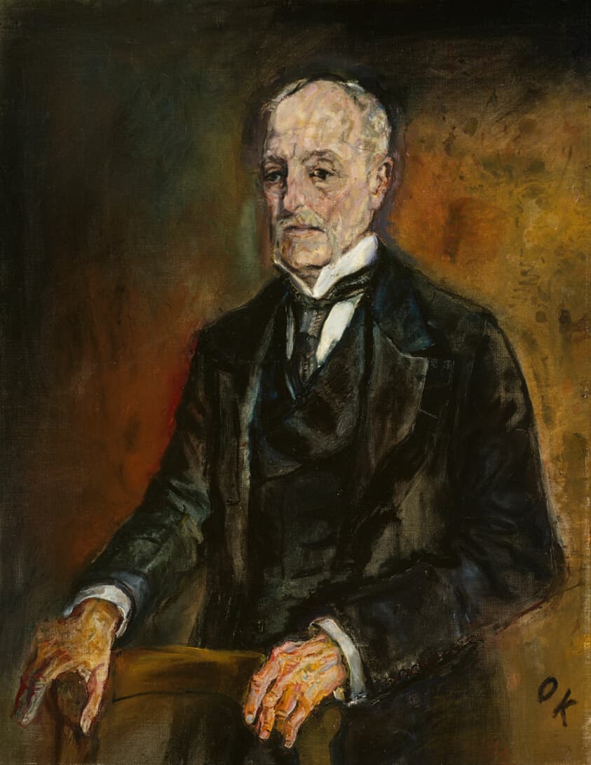 Portrait of man in suit against background of yellow and orange.